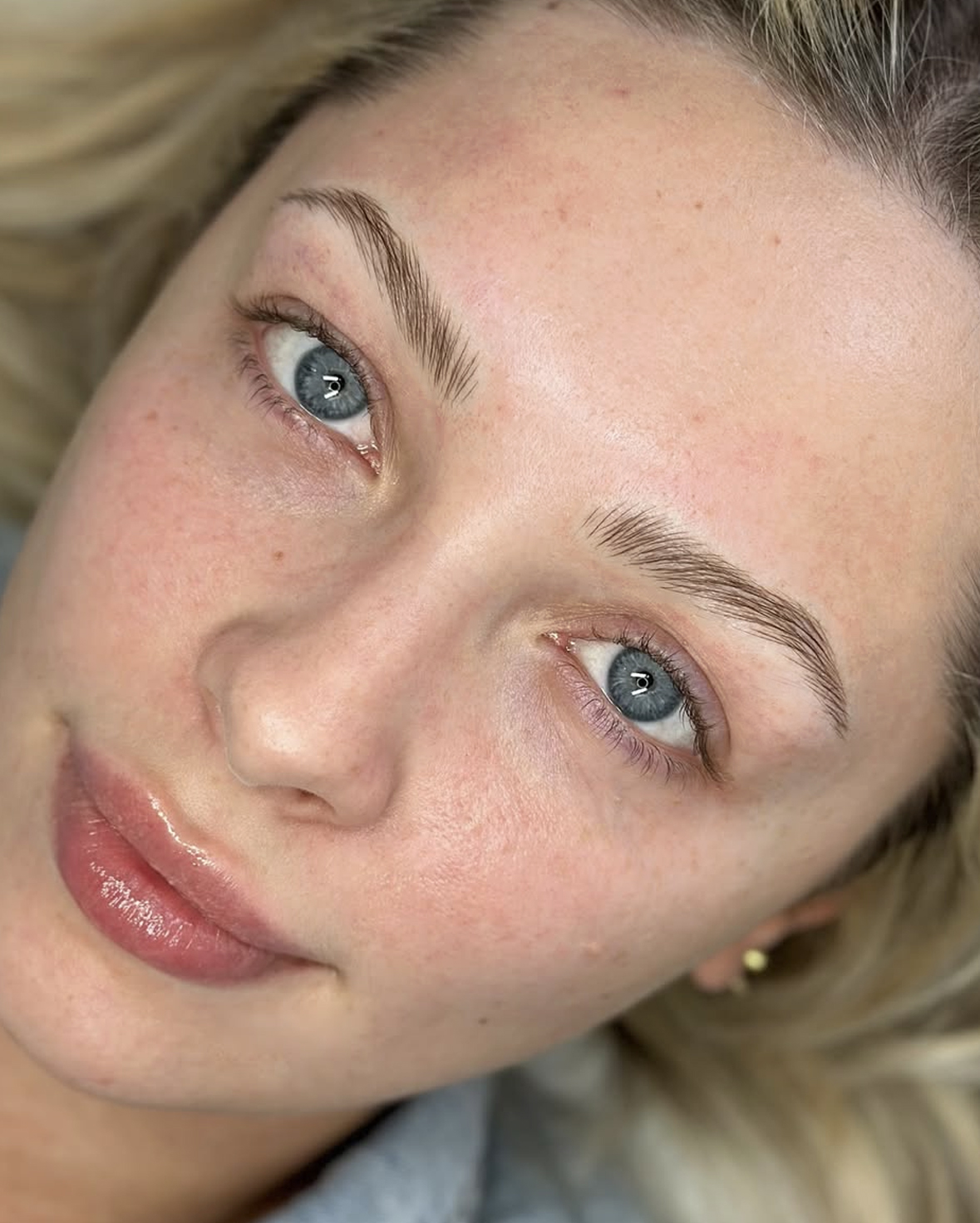 Woman with clear skin and light blue eyes looking at camera