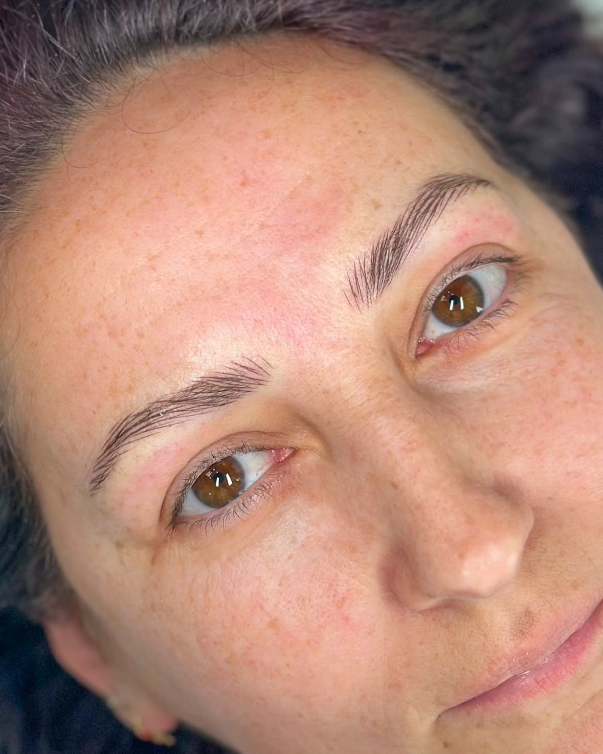 Close-up of woman with expertly groomed eyebrows looking content