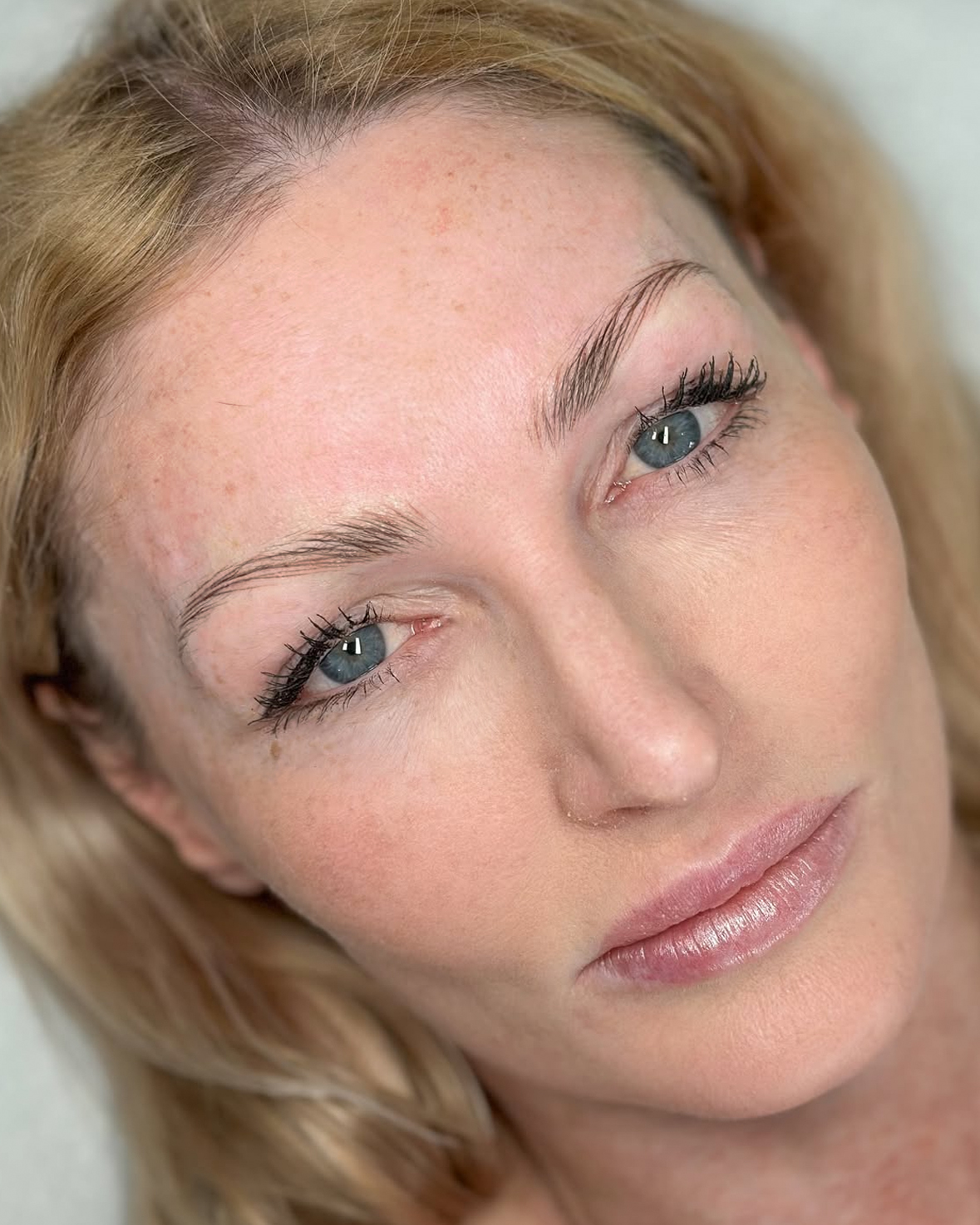 Woman with natural makeup and blonde hair looking serene